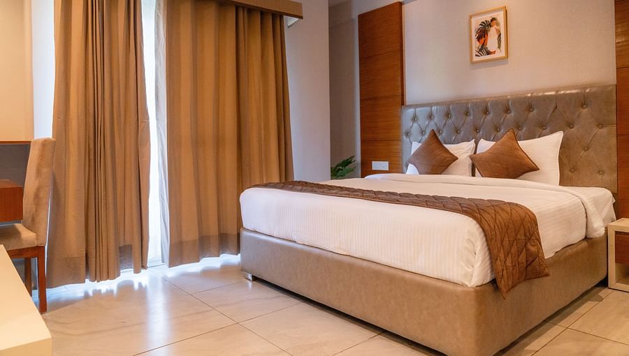 A large bed of a Super Deluxe Room at Montclair Ananta, Elite