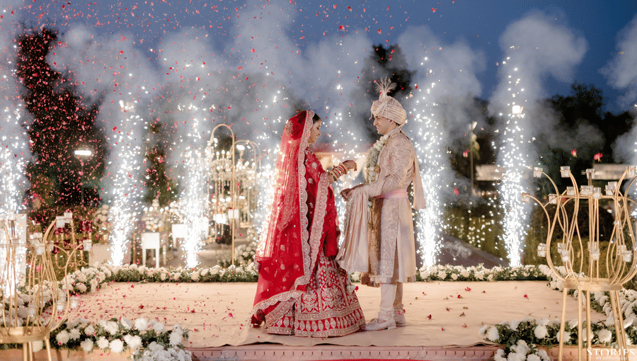 Bride and groom making a grand entrance with fireworks during a night wedding at Umaid Palace.