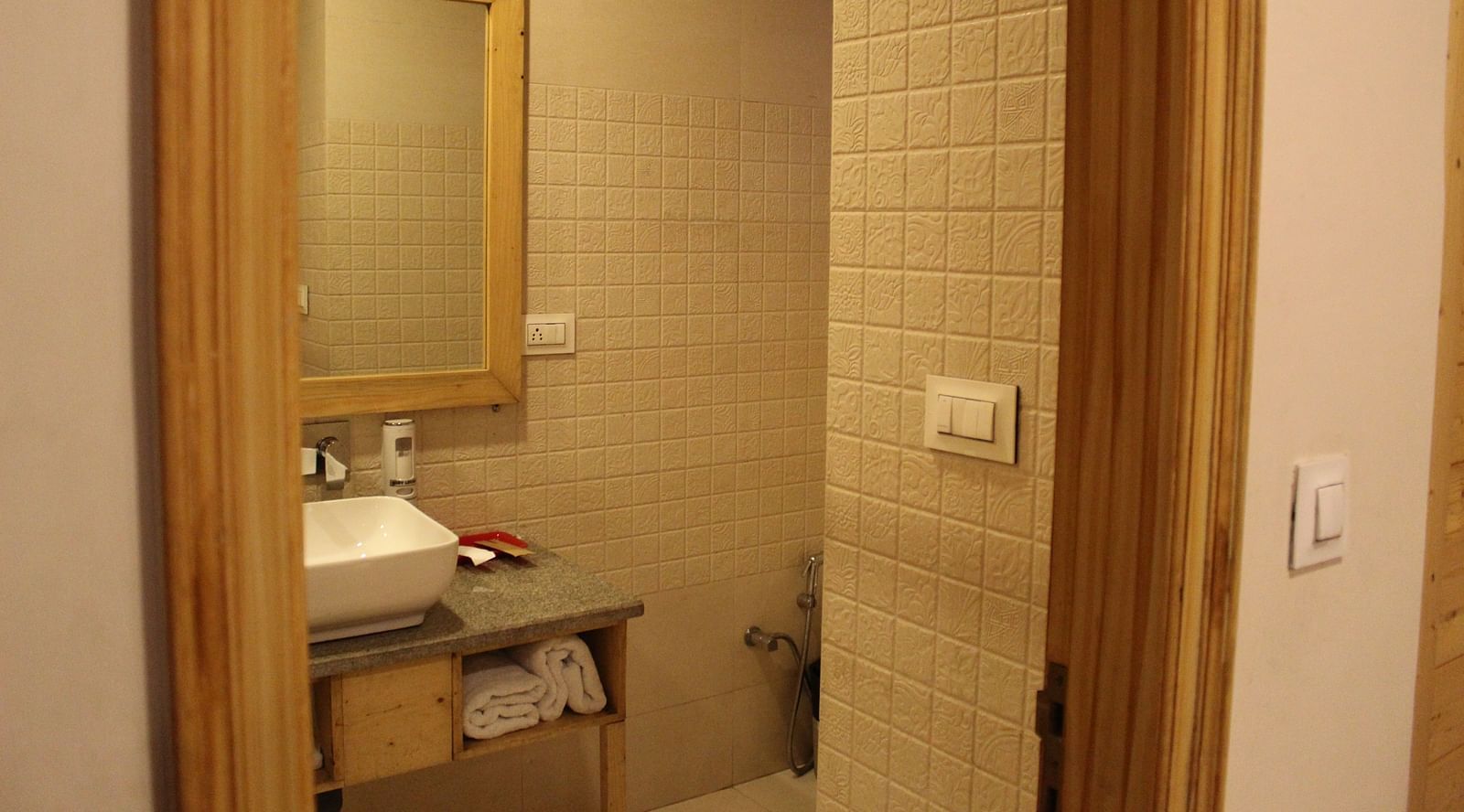 Compact bathroom with a mirror, sink, and towel rack at Dagshai Manor Kasauli - Inde Hotels.