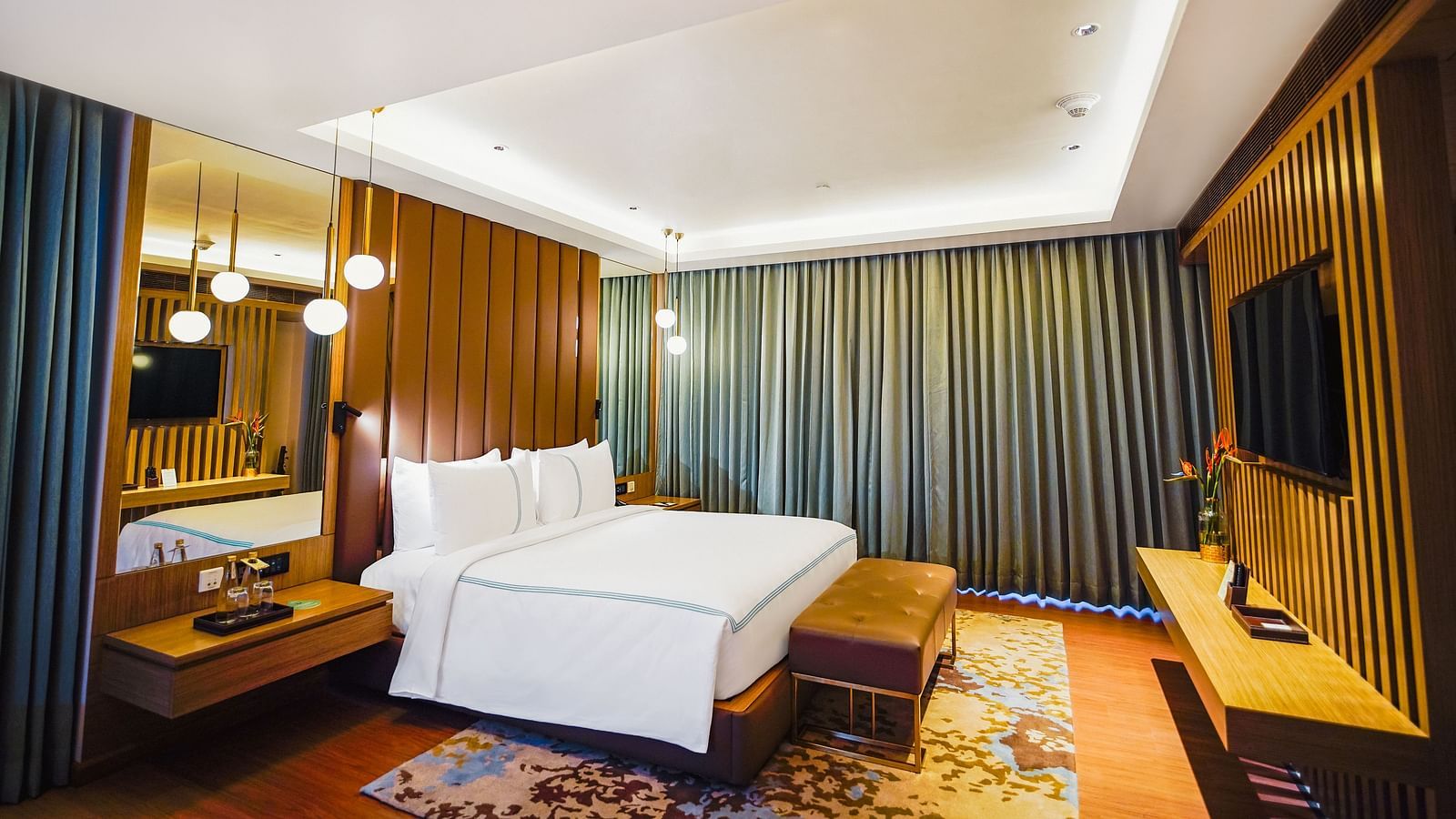 Grand Velammal Suite with a large bed placed in front of the television, a bed runner and a night stand - Grand Madurai by GRT Hotels