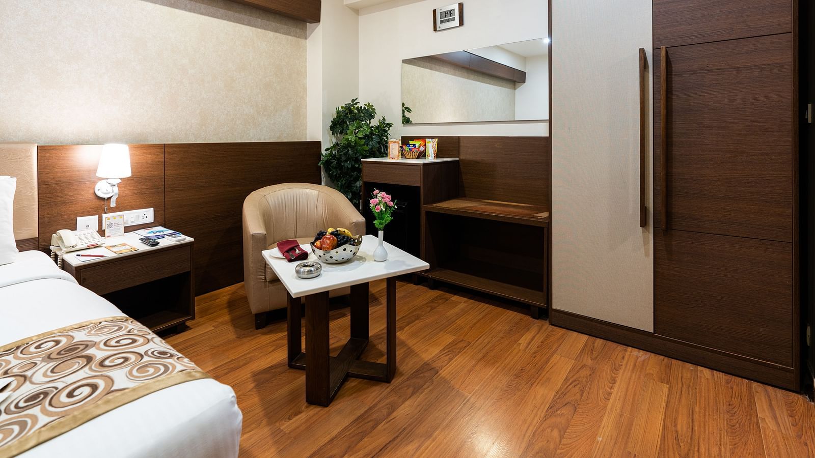 overview of a room with a single seater sofa and a table inside one of the rooms - Hotel Pai Vista, Mysore