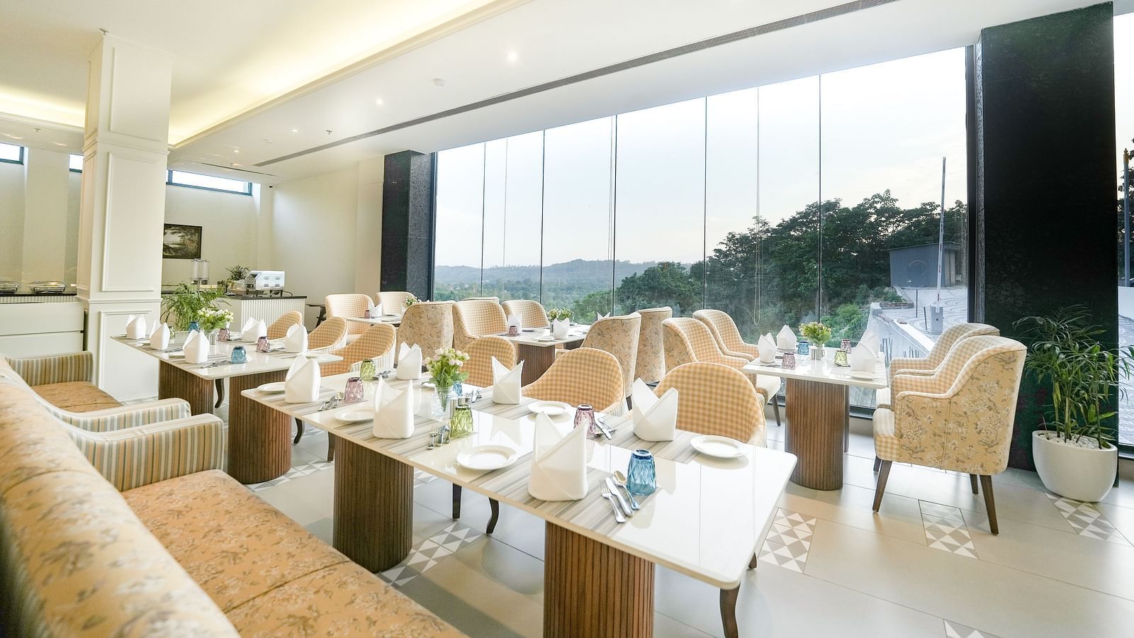 An image showcasing our cosy restaurant with dining arrangements that offer views of the mountains through the large windows - NAMAMI BY ZENQ BANKHANDI