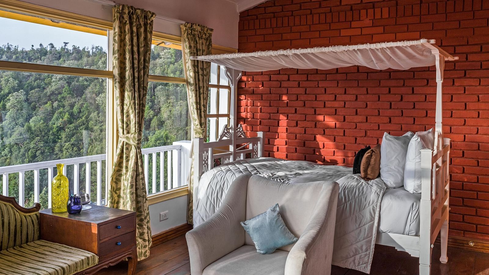 Sitiing area with sofa and large window on the side at Te Aroha by Shervani Mukteshwa