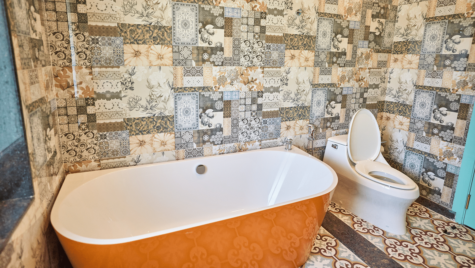 A bathtub with a western toilet to the side at Mayfair Manor, Alibag