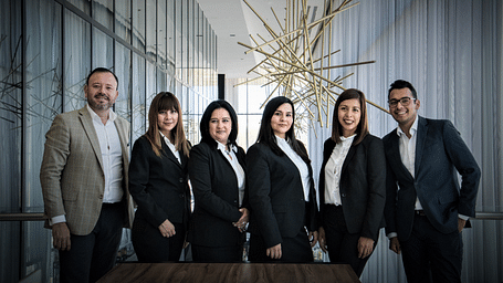 a group of professionals in suits posing for the camera