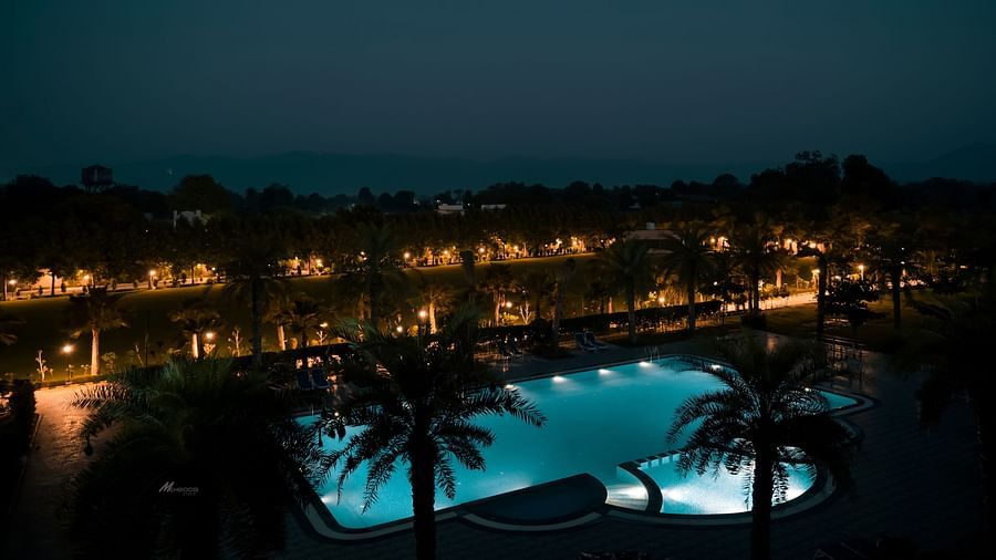 Pride Ranakpur Resort Convention Centre - view of the property swimming pool at night illuminated with lights underwater