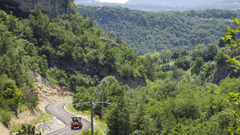 Image of a winding road through a mountainous landscape.