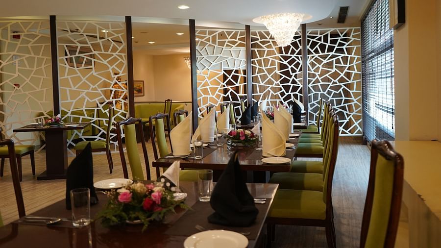 An image of a restaurant featuring  chairs, tables, and a chandelier light on top - Five Elements Hotels North Avenue, Delhi