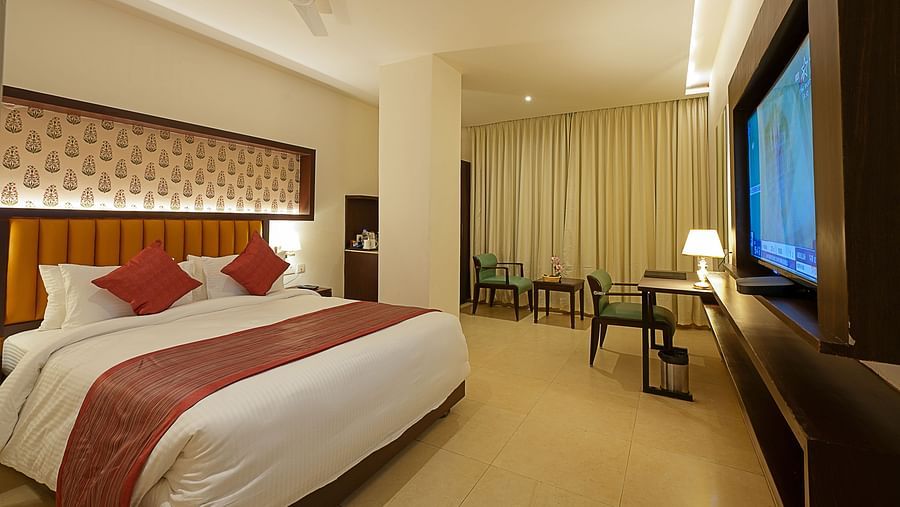 Deluxe room with a television and a king size bed at Grand Continent, Secunderabad
