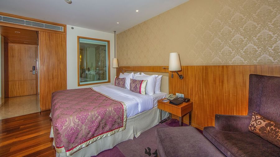 room with king size bed and wooden flooring at hotel bawa international