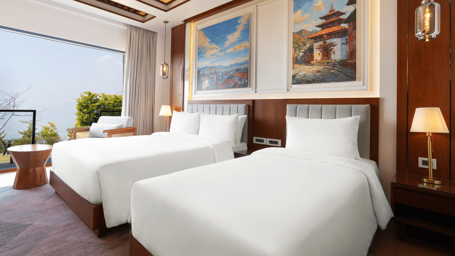 Hotel room at Royal Tulip Shivapuri National Park - Kathmandu with twin beds, clean linens, framed artwork, and a large window facing the hills.