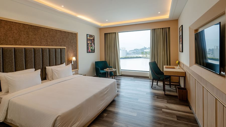 the Superior room featuring a king-sized bed, a seating area, and large windows offering scenic views
