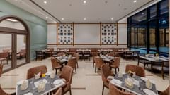 A chic dining area with comfortable seating and a well-arranged layout, perfect for an elegant dining experience - Sarovar Portico, Ajmer