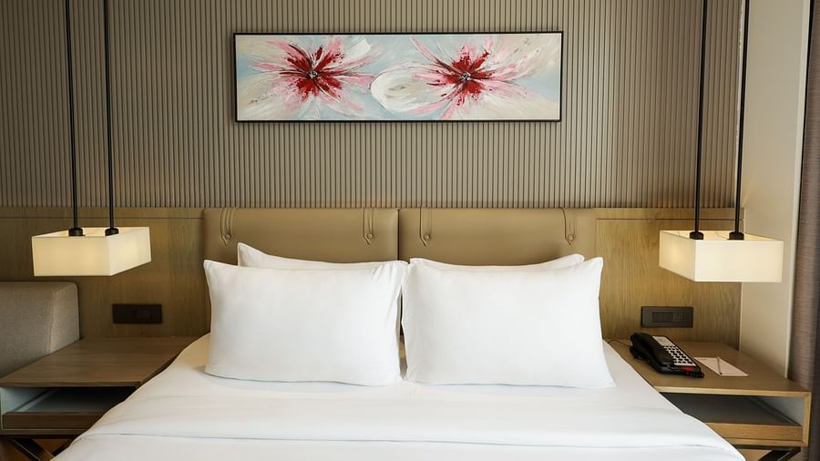 Elegant room with a bed and floral artwork above the headboard at Ramada by Wyndham Sonipat Murthal