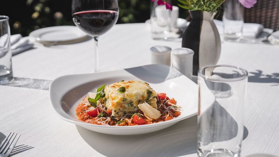 image of lasagne served with a glass of wine at The Claridges Nabha Residence