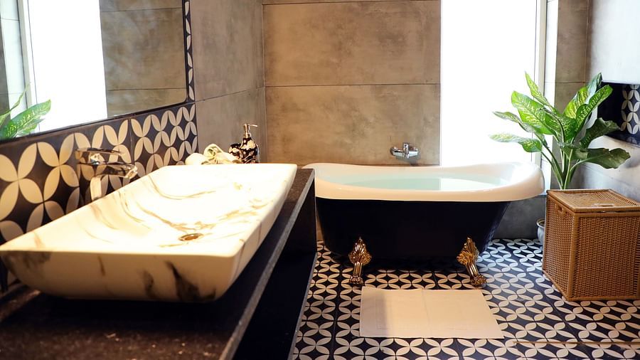 A modern bathroom featuring a sleek wash basin and a luxurious bathtub at Tisya Farms, Gurgaon.