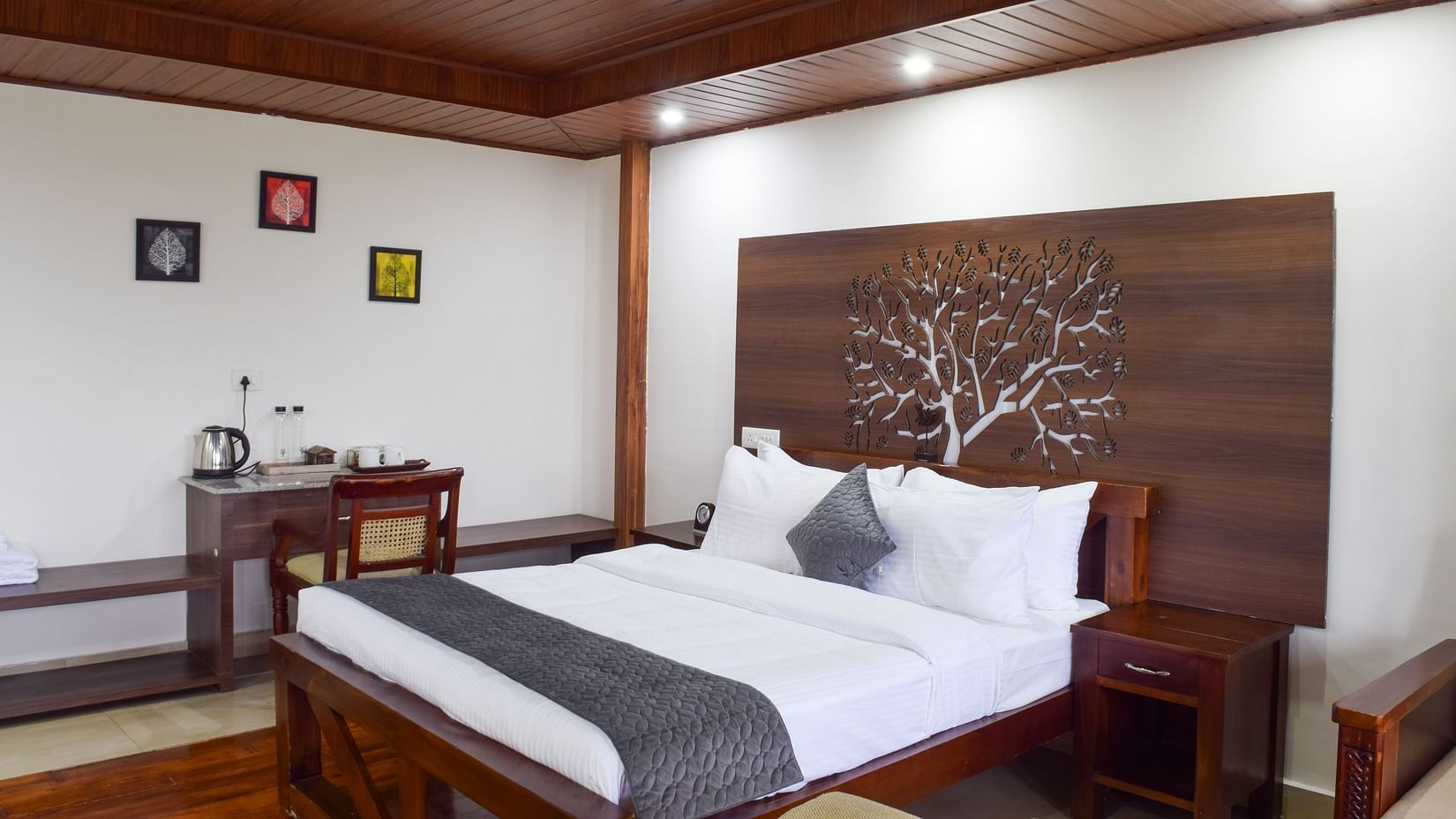 Image of the premium room at the resort featuring a king size bed with white mattress, pillow and a grey bed runner | Ibex Stays and Trails