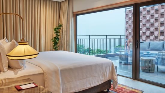 A room with an attached balcony overlooking greenery and sitting area at The Dukes Retreat.