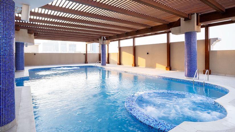 A large swimming pool with roof enclosures at La Maison Hotel, Doha