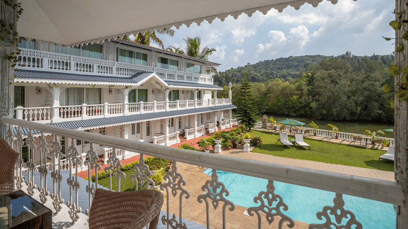 The Maharaja Balcony offers a splendid view of the facade, pool and thick vegetation surrounding the premise - Stone Wood Riverfront Resort, Siolim