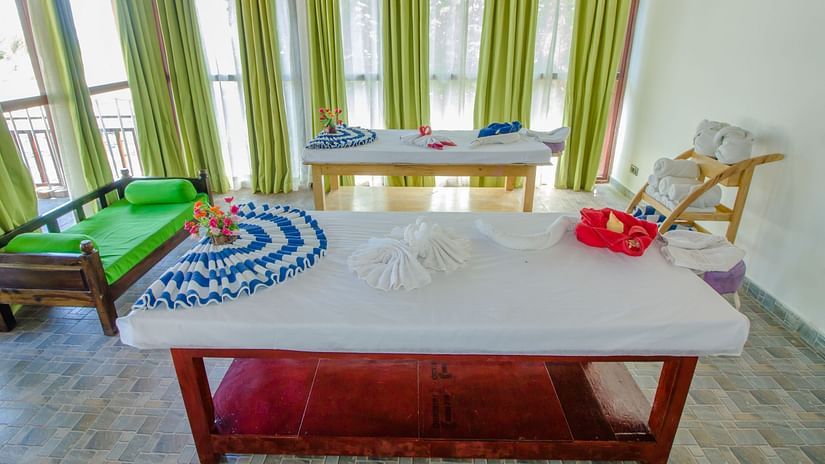A massage table inside Neil Ocean Spa with a sofa on the side - Symphony Summer Sand Beach Resort And Spa, Neil island