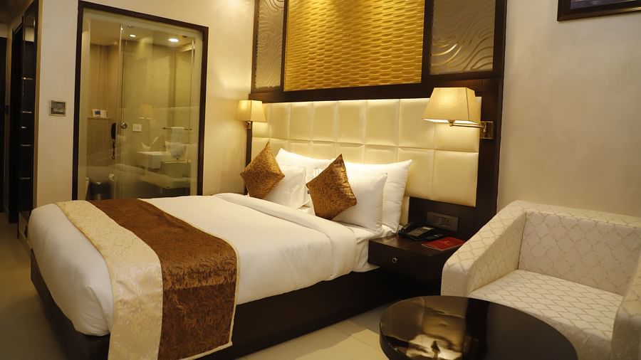 Superior Room with plush bed and a sitting space next to it