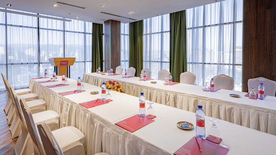 An overview of a meeting room with a parallel table set-up with water bottles and chairs in view at Ramada by Wyndham Addis, Addis Ababa.