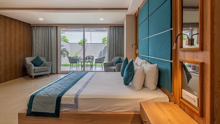 A well-appointed guest room with a large bed and a view of the outside area at Hotel Highway King Shahpura.