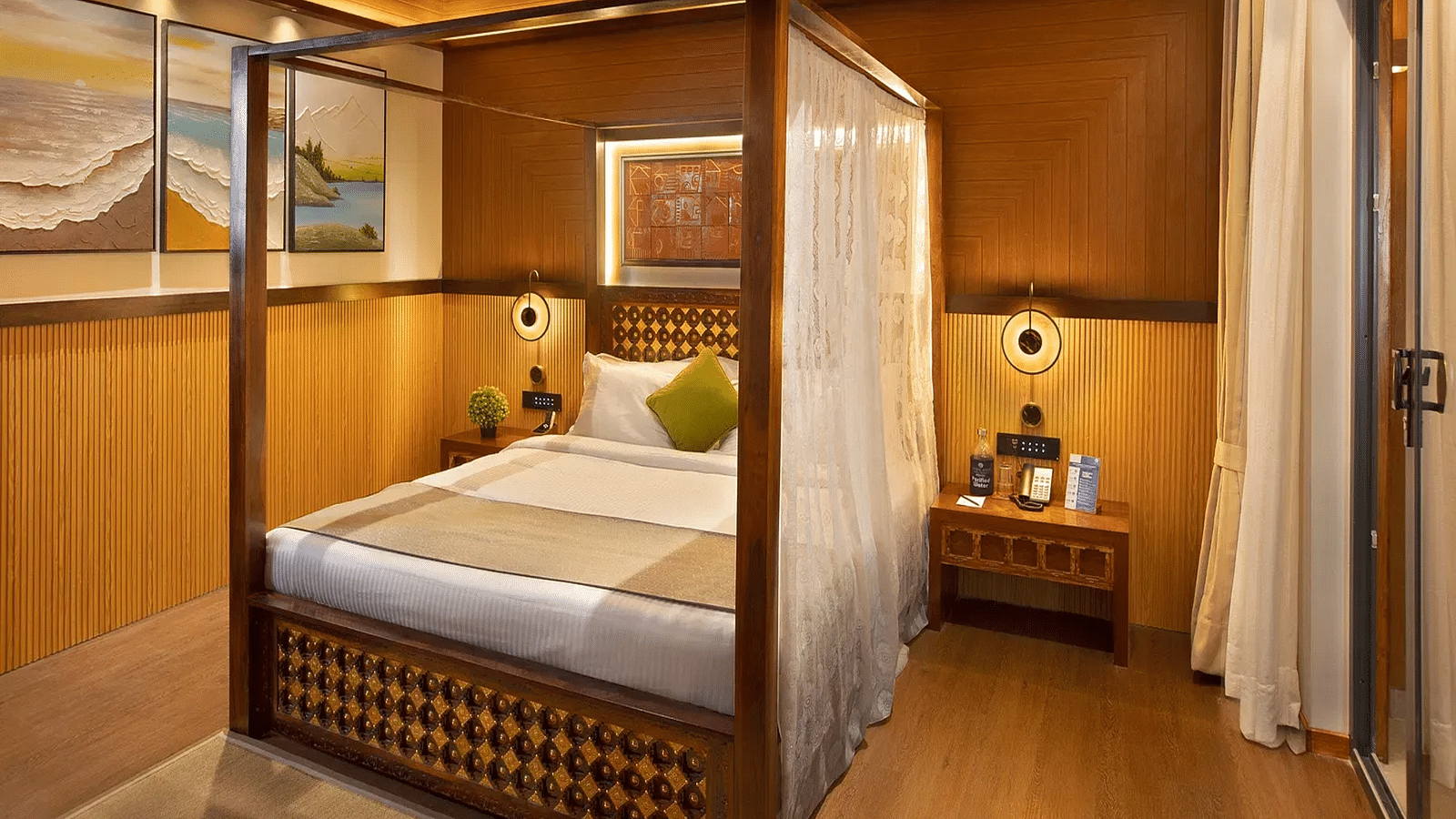 Coral Teal Suite at Coral Reef Resort and Spa in Havelock featuring a plush canopy bed with a nightstand next to it and a lamp over it
