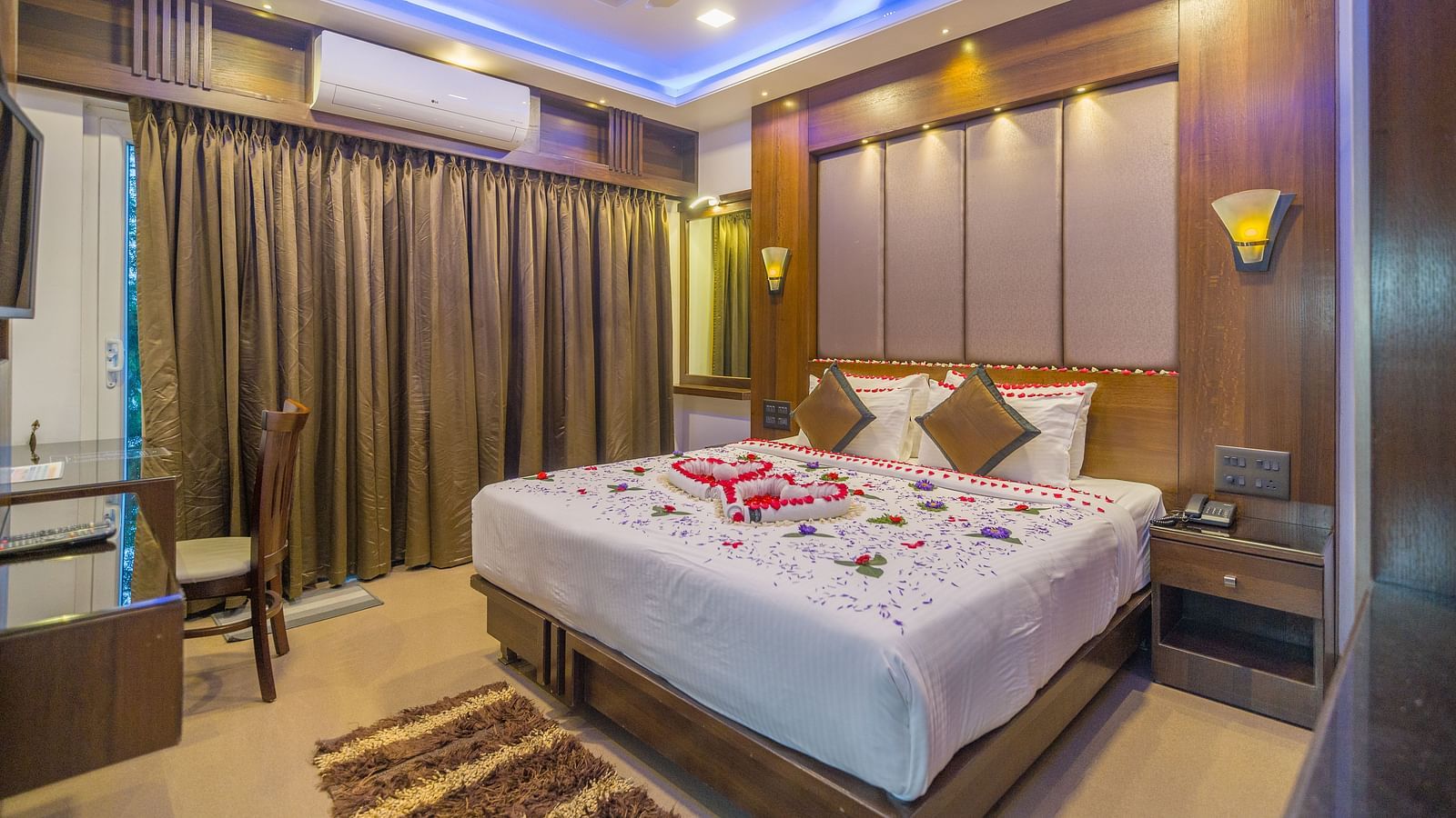 Image of a room with a bed decorated with flower petals at Hotel Altitude, Madikeri.