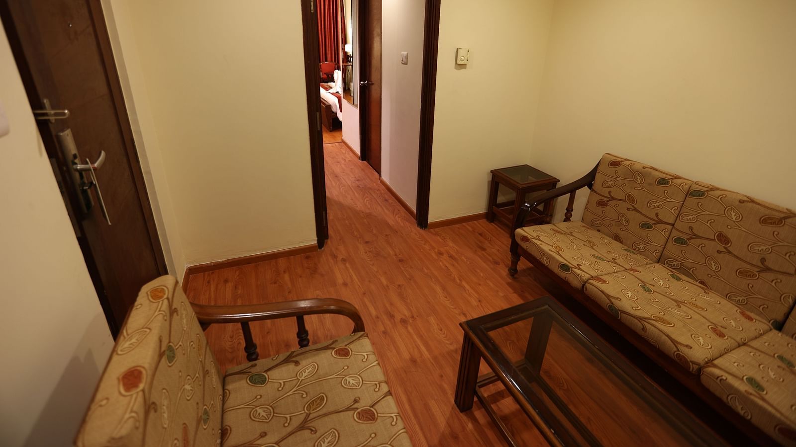 A living room with a sofa set, coffee table and a hallway