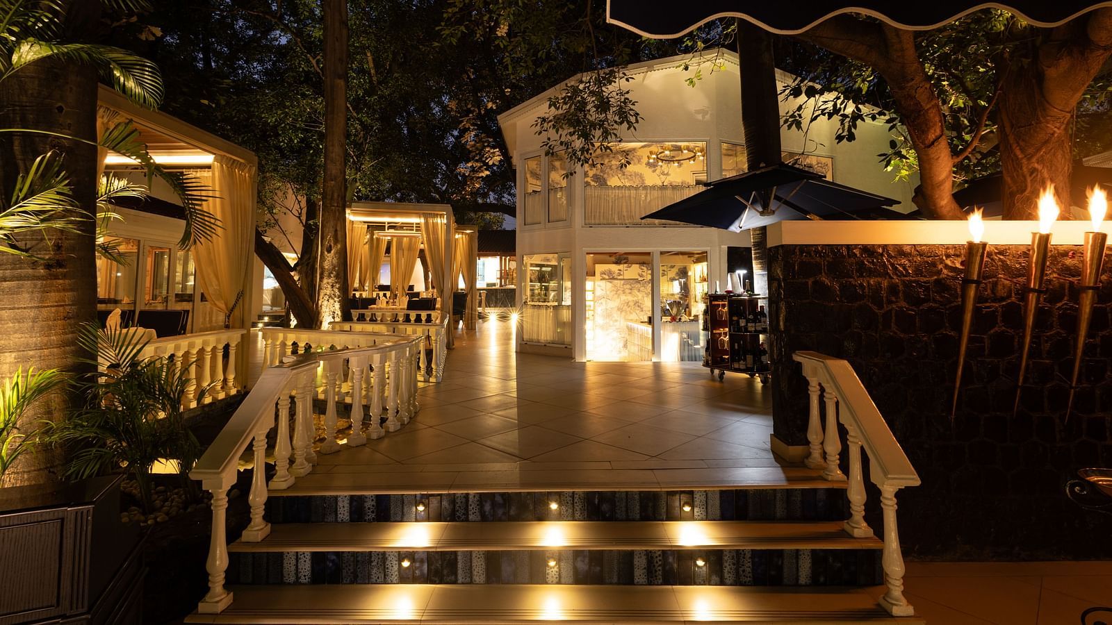 Sevilla restaurant entrance at The Claridges New Delhi, beautifully illuminated at night, showcasing its charming alfresco and indoor dining spaces