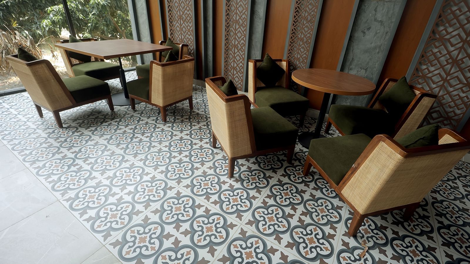 Indoor seating with wooden armchairs and patterned tiled flooring under warm lighting at Wyndham Garden.