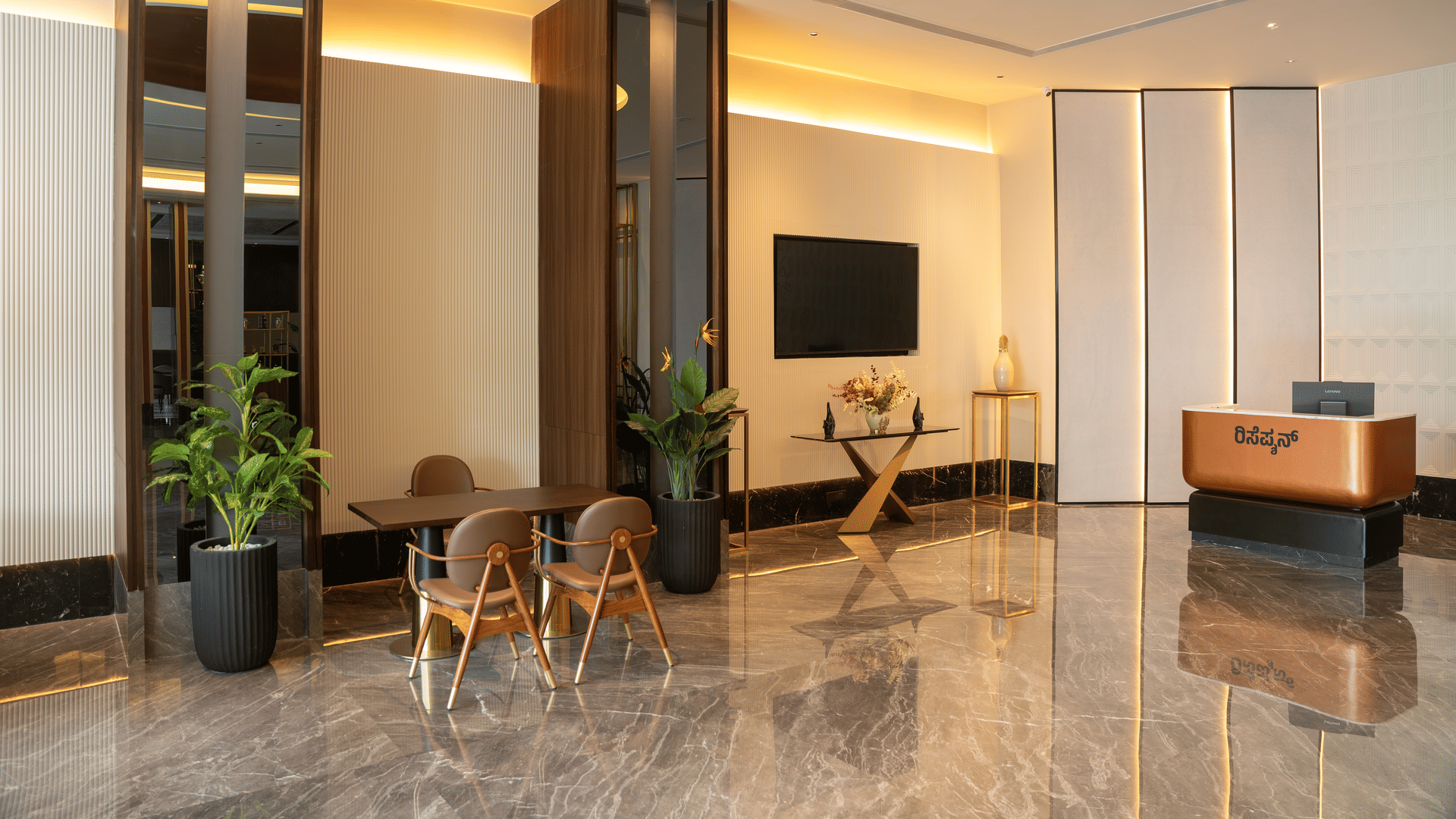 Warmly lit reception lobby with a copper front desk, polished marble floors and wood-panelled walls at RG Grand Hotel, Bengaluru