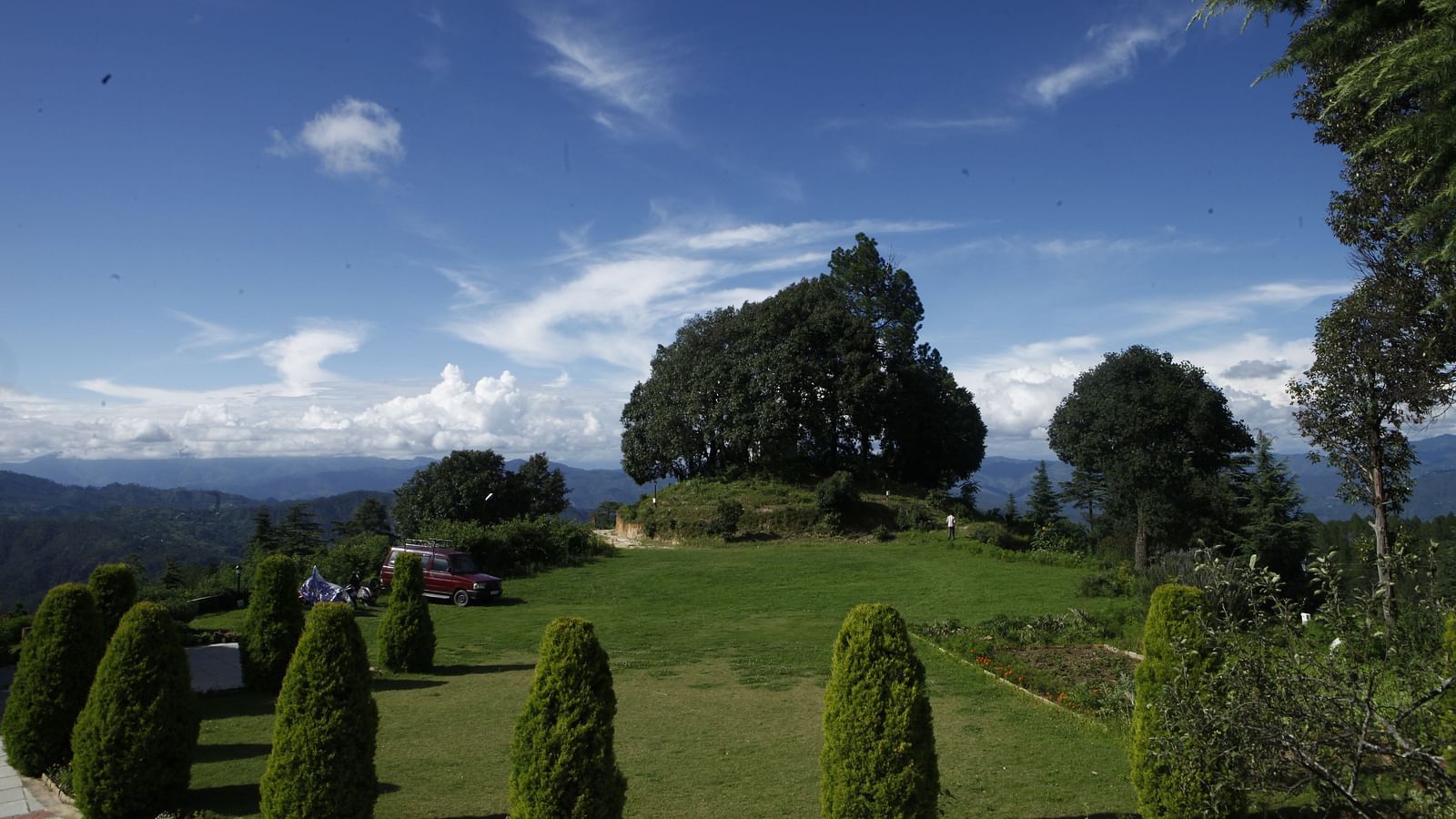 A vibrant wedding lawn in Almora with a scenic backdrop of hills and trees - BluSalzz Escapade - Anant Rasa Resort