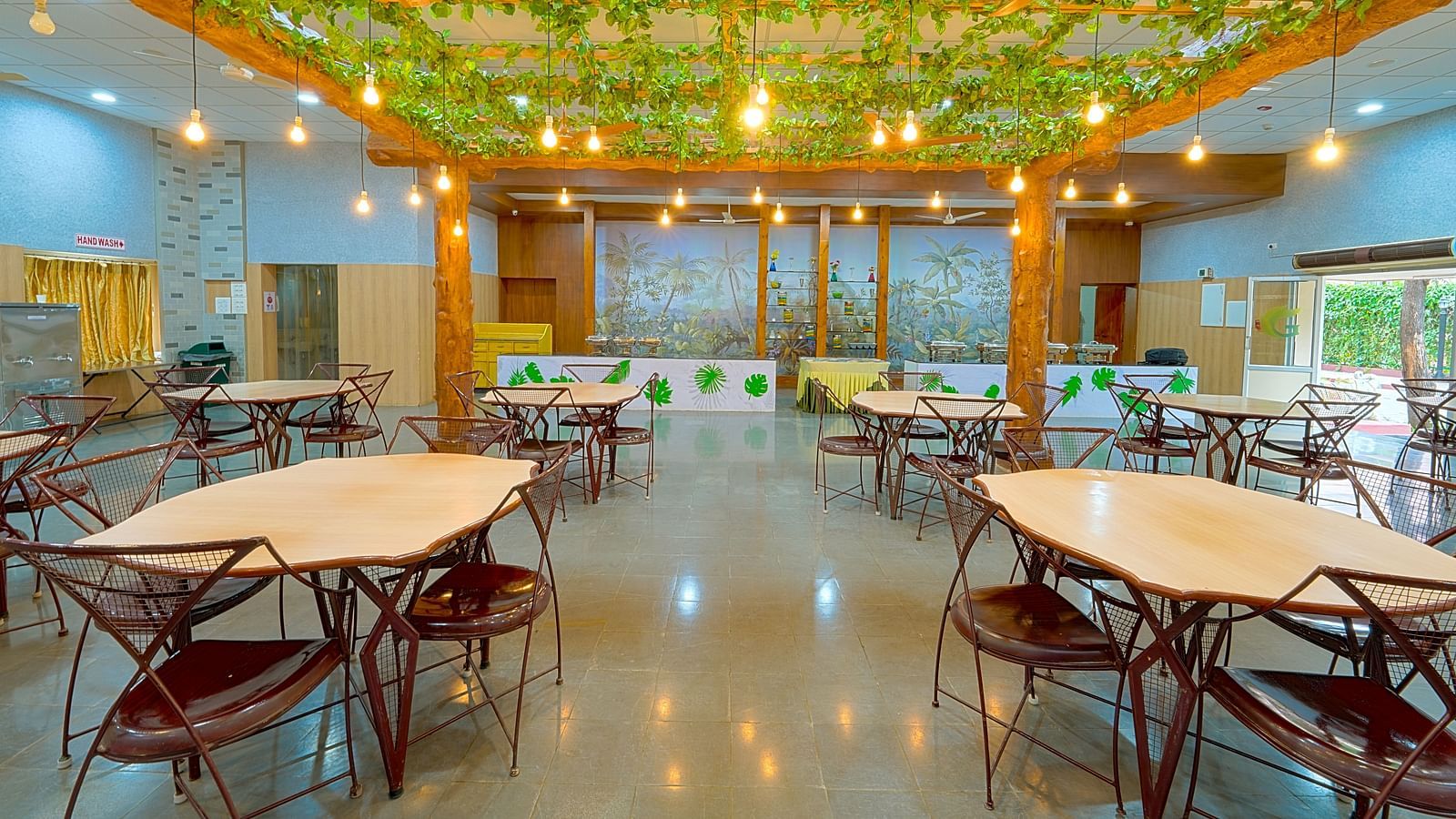 Dining tables and chairs placed in Greens Inn Restaurant - Top Restaurant in Hyderabad.