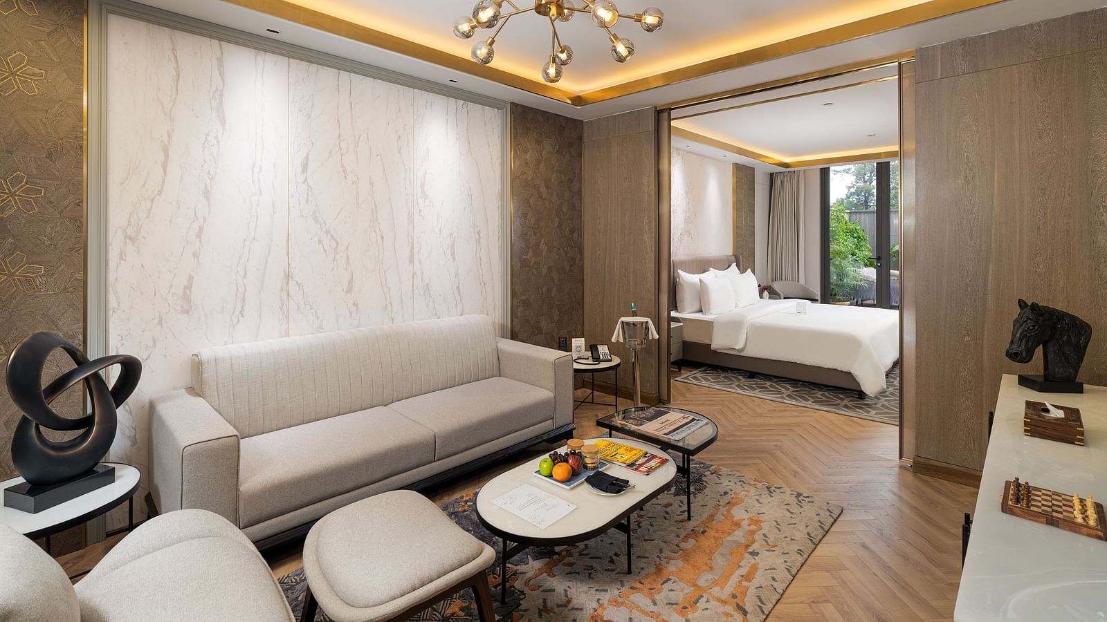 Elegant Nirvana Suite living area with a stylish sofa, a chic coffee table, and an open view into the spacious bedroom - Nirvana Luxury Hotel, Ludhiana