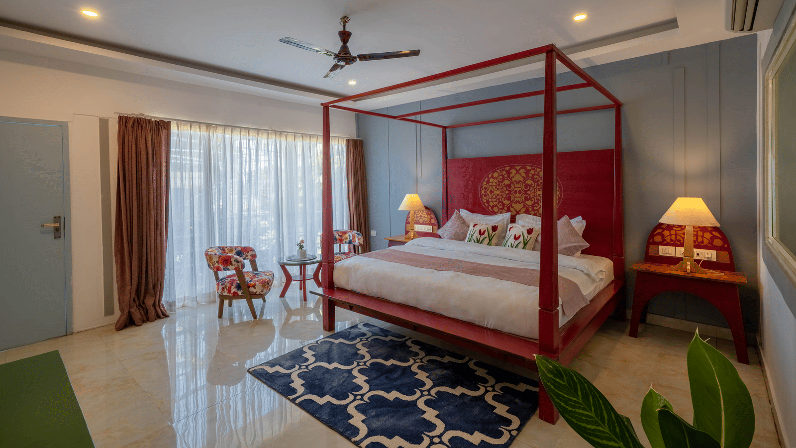 A room with warm ambient lighting, a 4-poster bed, a cosy seating area, and a potted plant - Perfectstayz Koko Maya