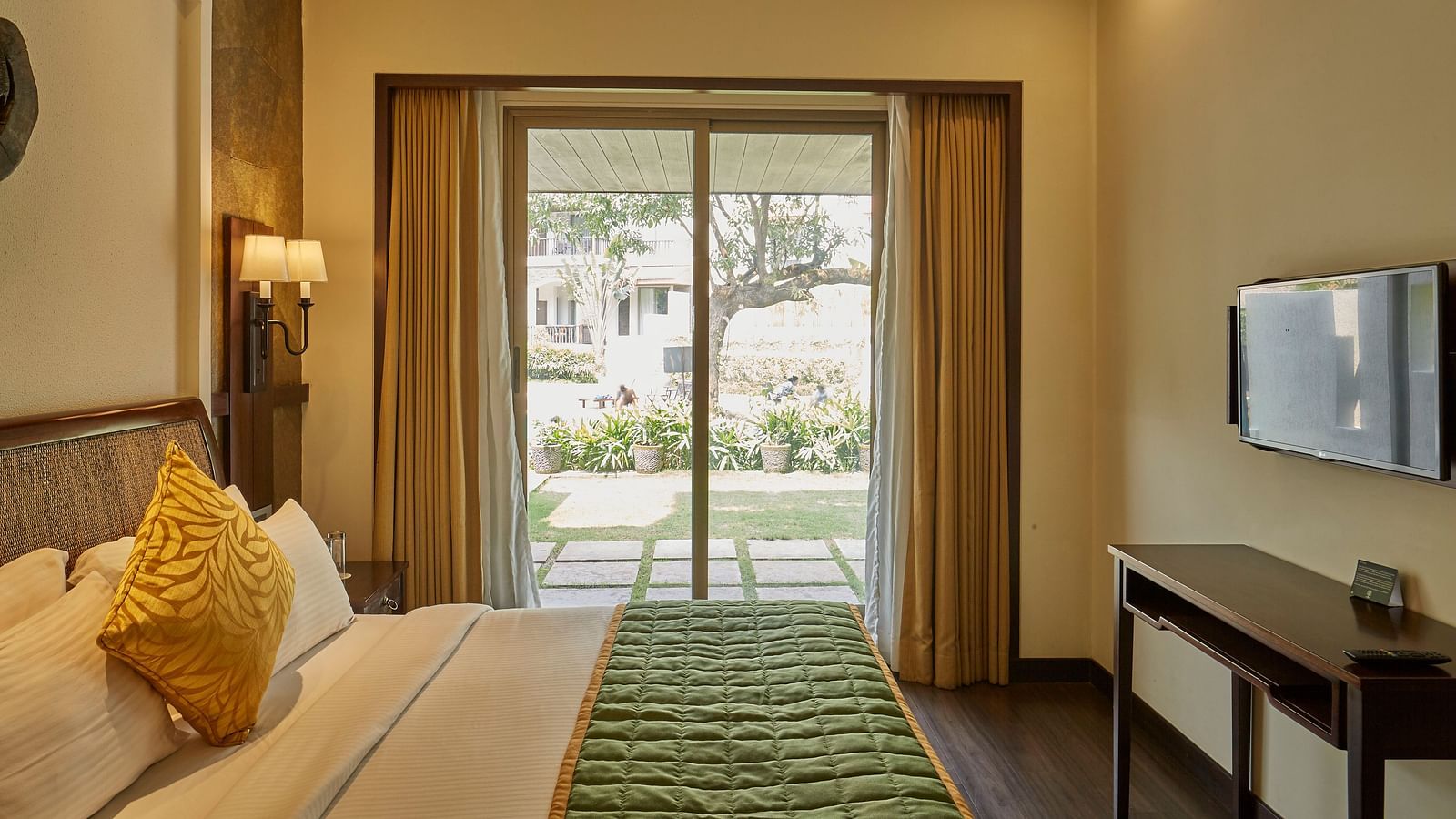 an image of a bedroom with a glass patio door with outdoor view - Rhythm Lonavala