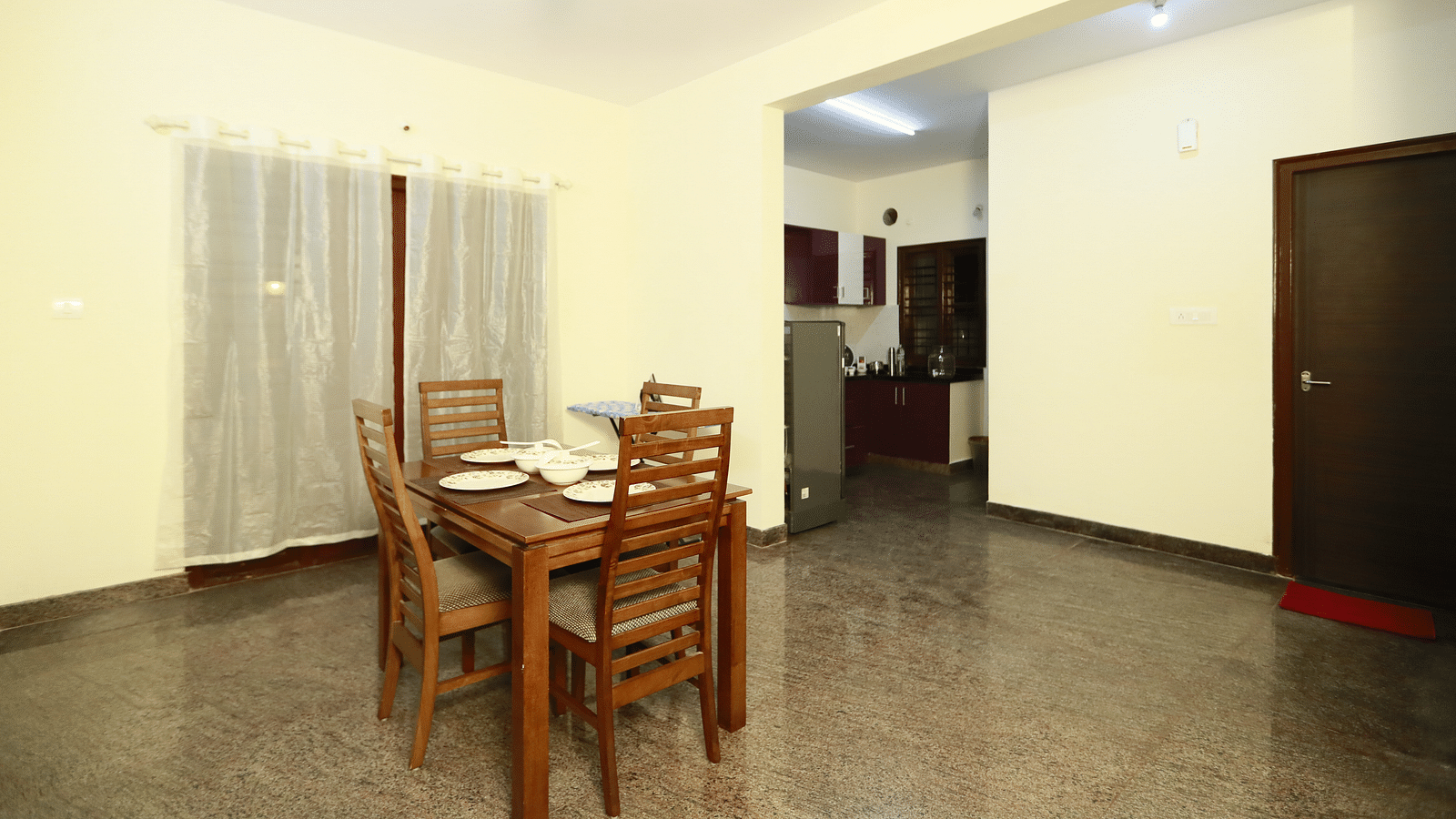 A dining seating near a window in 1BHK at Tranquil ABS Orchid Serviced Apartments.
