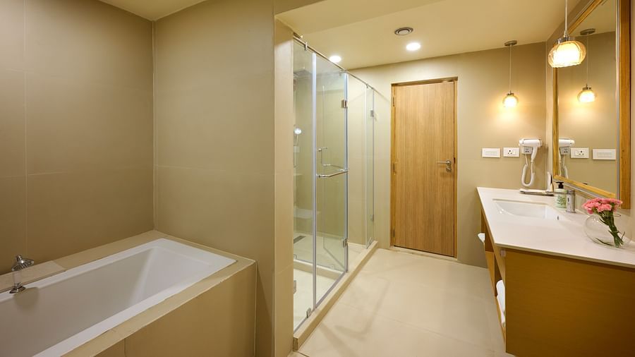 view of the bathtub, shower and wash basin in the bathroom of the Cottage at ABN Sarovar Portico, Jim Corbett