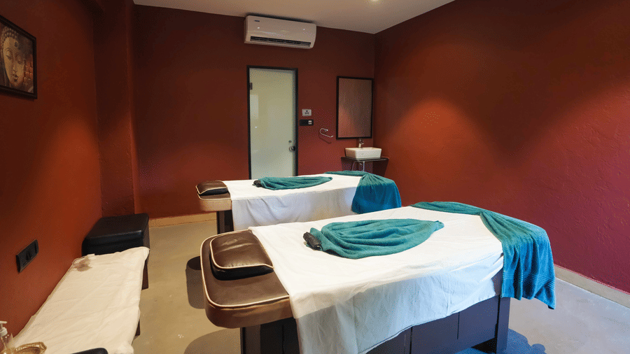 A view of a Spa at Adamo The Village featuring 2 beds, an air conditioning, a ceiling fan, and a closed door leading to another room.