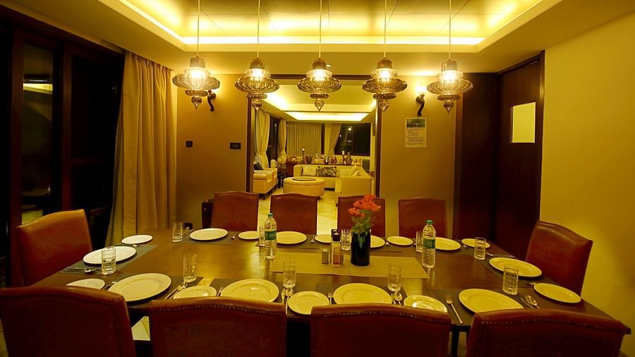 dimly lit dining roomw ith dining table and chandelier - Aranya Himalayan Retreat, Mashobra