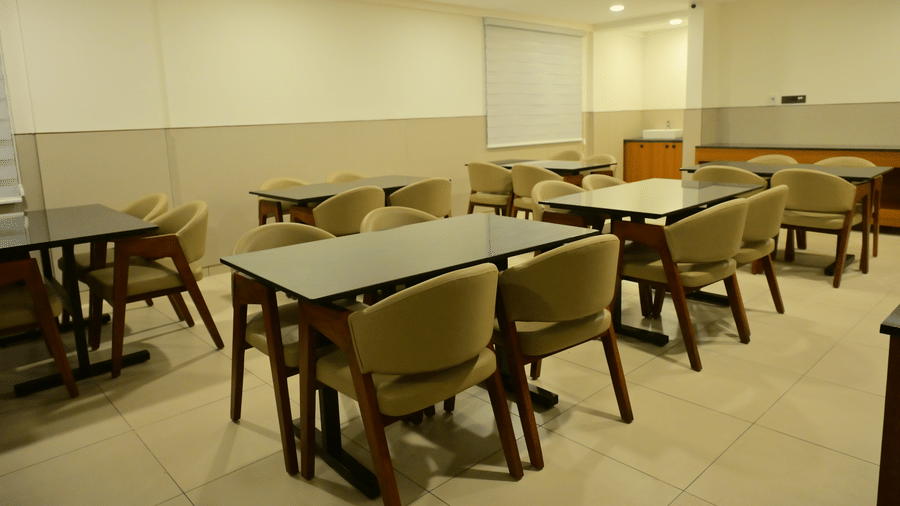 Banquet hall of Bhavanis Vista By Icon featuring tables and chairs arranged in rows.