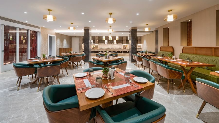 Dining area featuring plush seating, wooden tables, and warm lighting - Clarks Inn, Indore