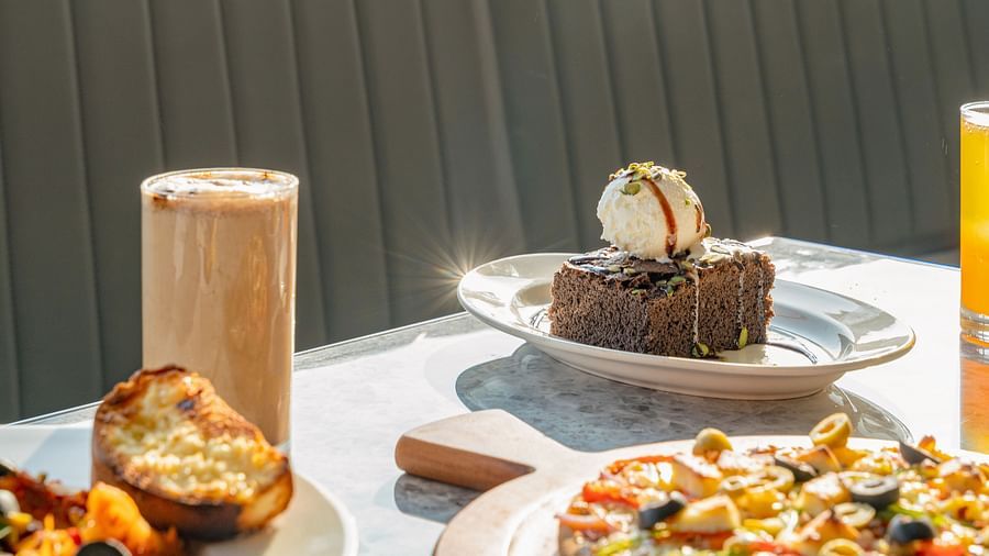 Table display with chocolate brownie topped with ice cream and slices of toast beside a fruit juice glass at Clarks Inn Suites, Hyderabad