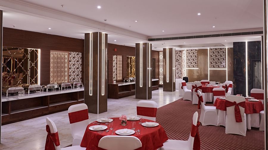 An image of a banquet hall with chairs placed around round tables - Deventure Sarovar Portico, Patel Nagar