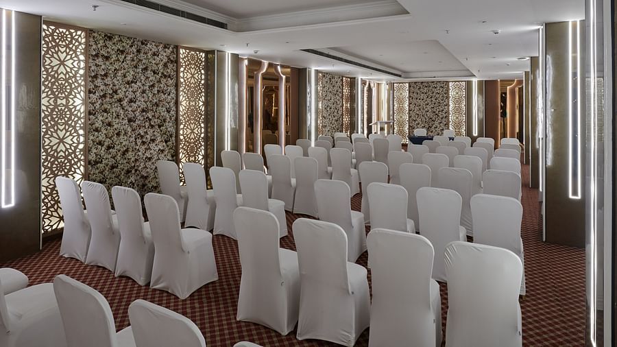 An image of a banquet hall with chairs placed towards the table of the speaker - Deventure Sarovar Portico, Patel Nagar