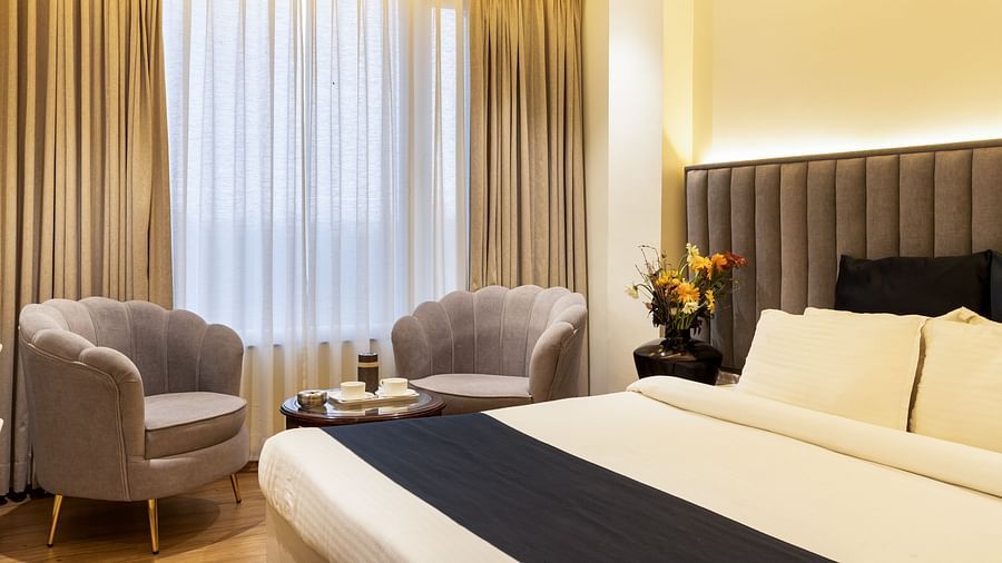 Double bed and two sofas at Luxury Premium Room at Hotel Meghdoot 