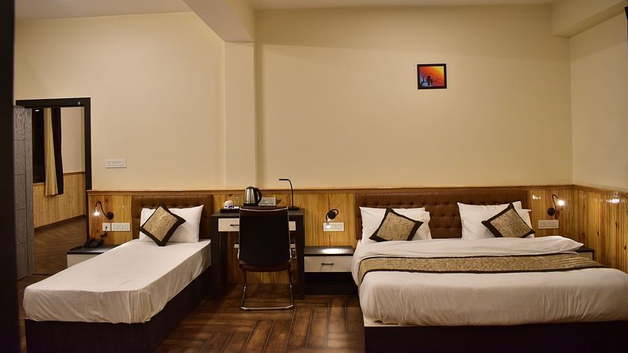 Deluxe Room Triple Occupancy - a luxurious room with a premium queen bed along with a single bed featuring room amenities like a wardrobe, television, a workdesk and more - Hotel Montana Vyoo